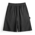Cement grey straight leg sports shorts with a loose fit and elasticated waistband on a neutral background.