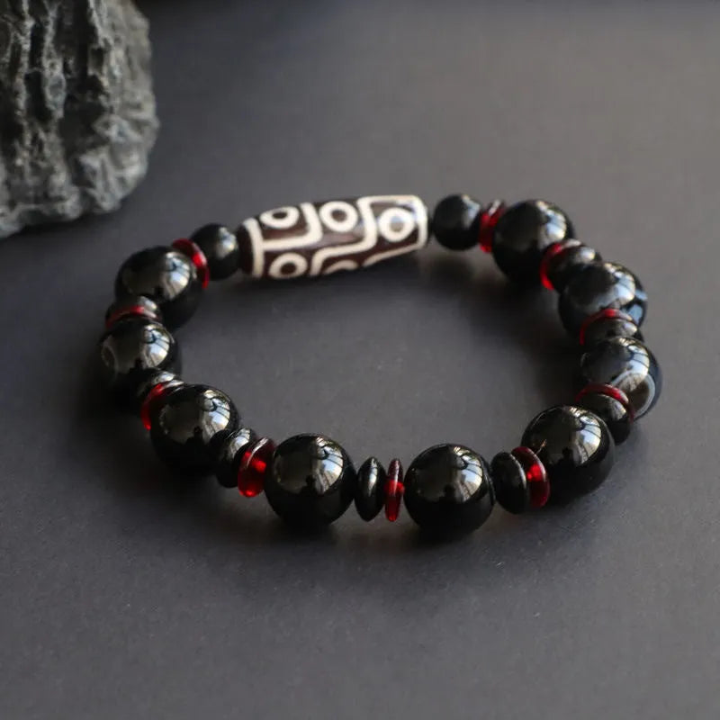 Black agate dzi bead bracelet with hand-woven construction and geometric 11mm beads