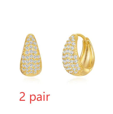 Golden brass diamond earclip earrings with simple geometric round design on white background