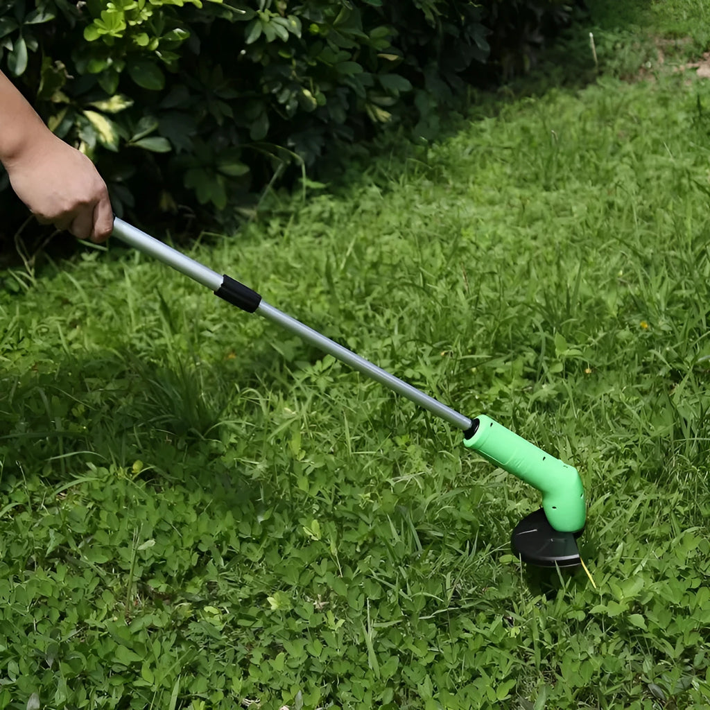 Cordless zip tie lawn trimmer with extension pole and protective debris shield on grass.