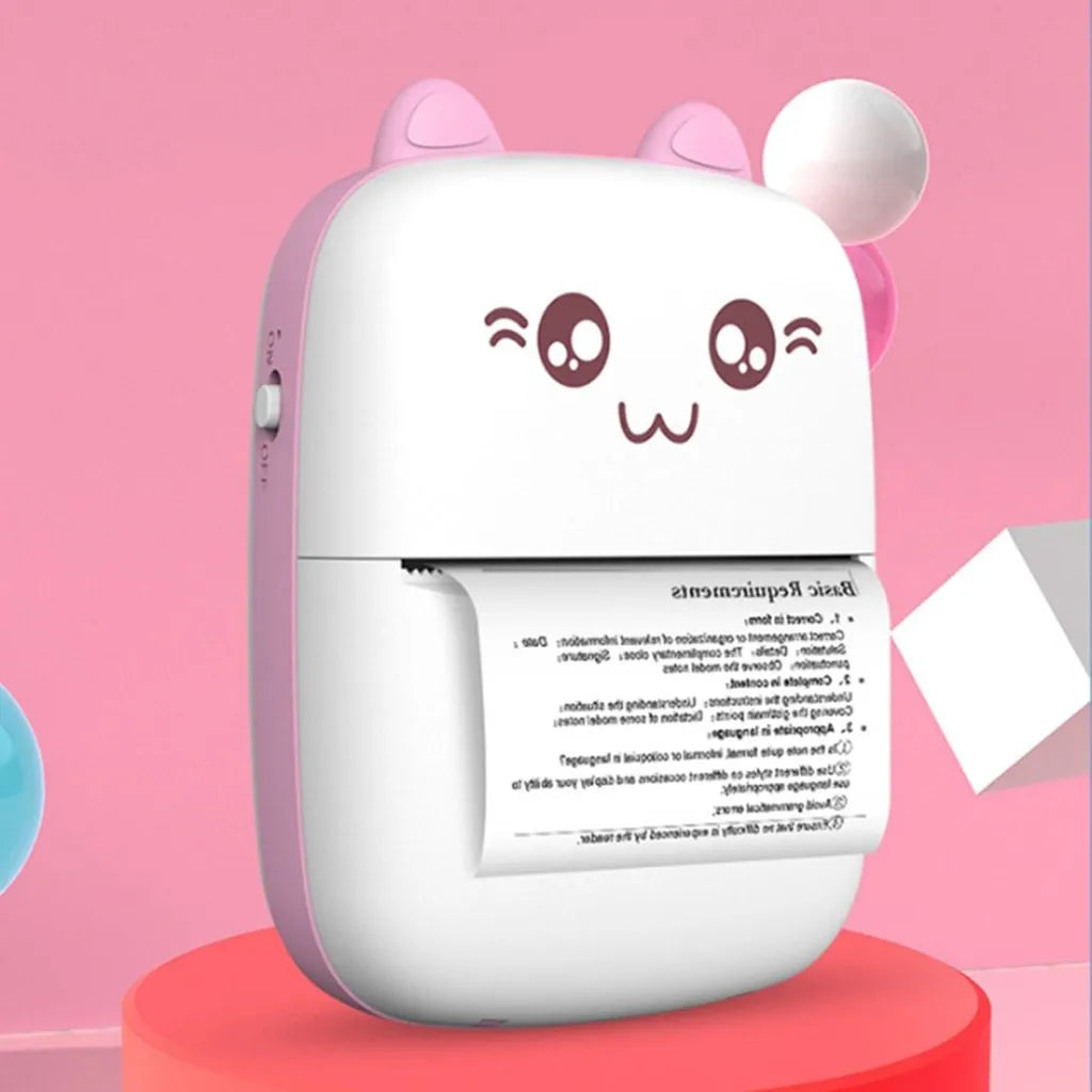Pink mini Bluetooth thermal printer on a desk with a phone and printed note, measuring 11x8x3.5cm