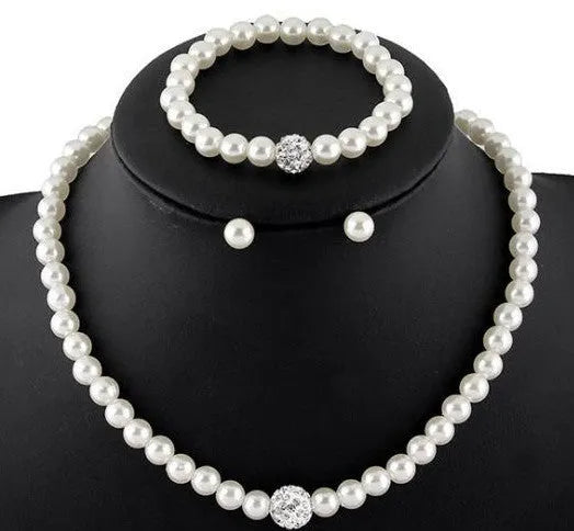 White plastic resin pearl-style jewellery set including necklace, earrings, and bracelet on display