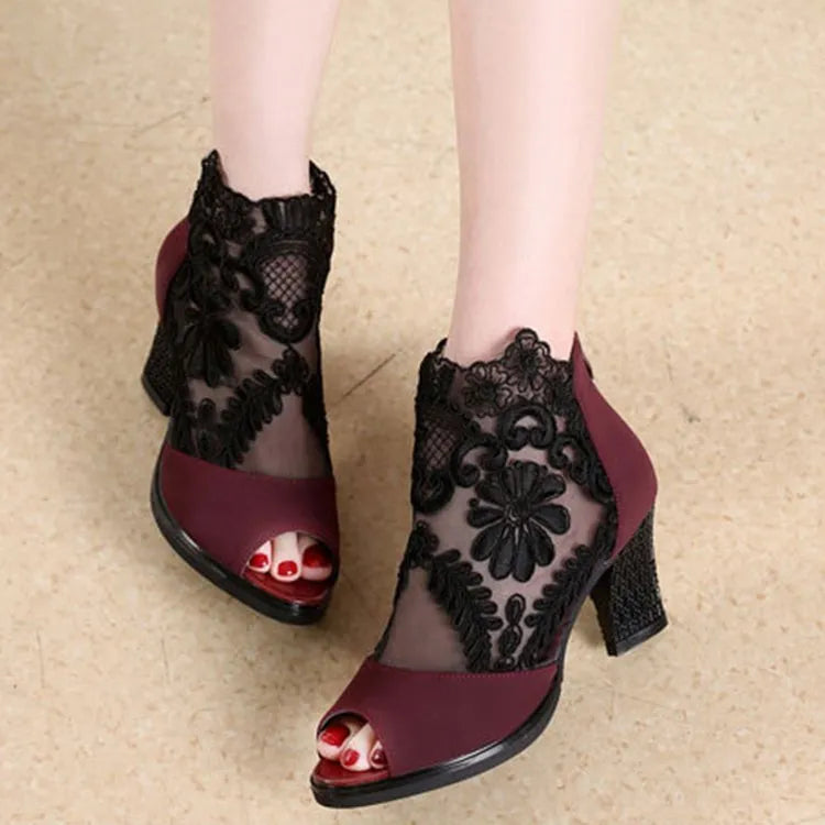 Black women's lace gladiator sandals with a zip closure, floral pattern, and a square high heel on a rubber outsole.