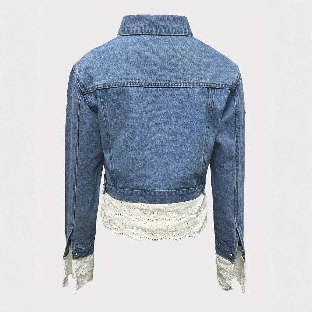 Blue women's denim jacket with white lace stitching details on the front, showing long sleeves.