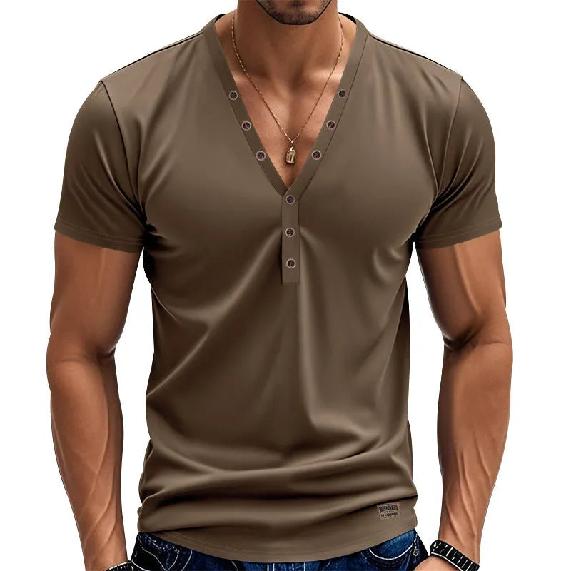 Man wearing a loose fit grey v-neck pullover top with button detail on the neckline