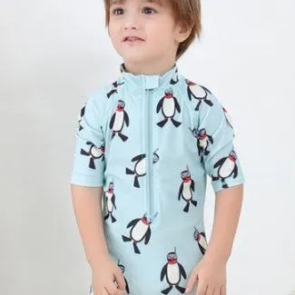 Boys' long sleeve penguin print swimsuit and matching swim cap set on a white background.