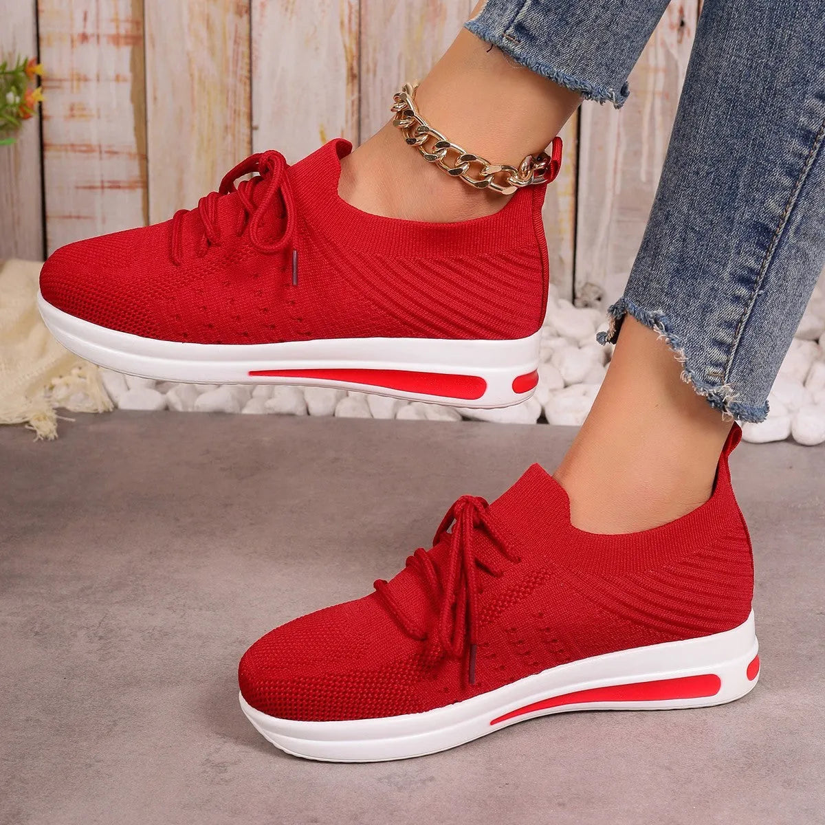 Women's low-top fly-knit sneakers in red with round toe and lace-up front.