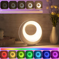 Small white RGB colour changing desk lamp with remote control on a table