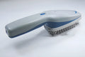 A white pet comb with a removable brush head and a handle housing negative ion and active oxygen technology.
