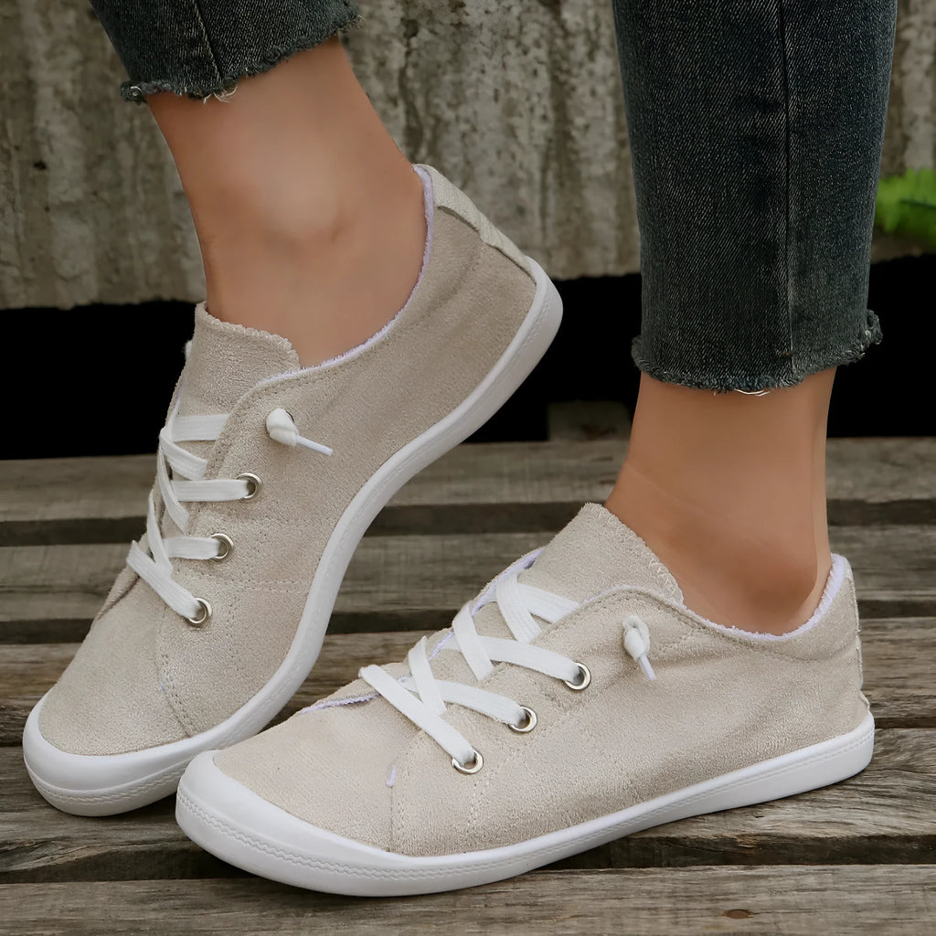Women's creamy-white low-top fabric casual sneakers with a rubber sole on a neutral background.