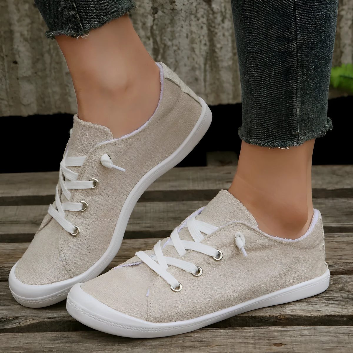 Women's creamy-white low-top fabric casual sneakers with a rubber sole on a neutral background.
