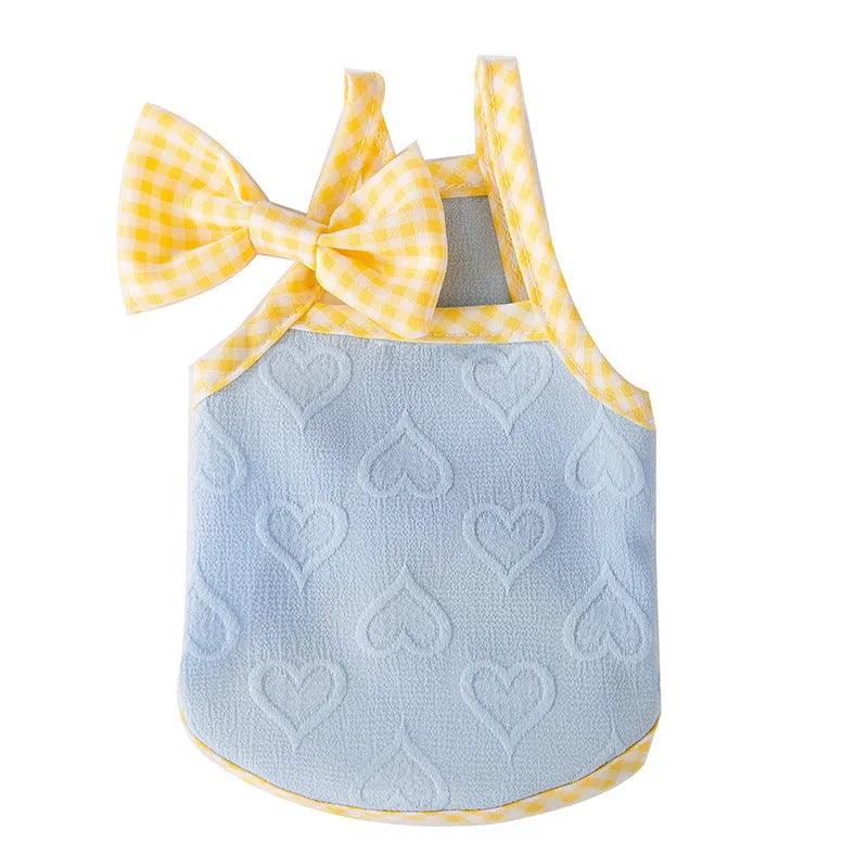Small dog wearing a blue elastic vest with a white heart and bow suspenders decoration.
