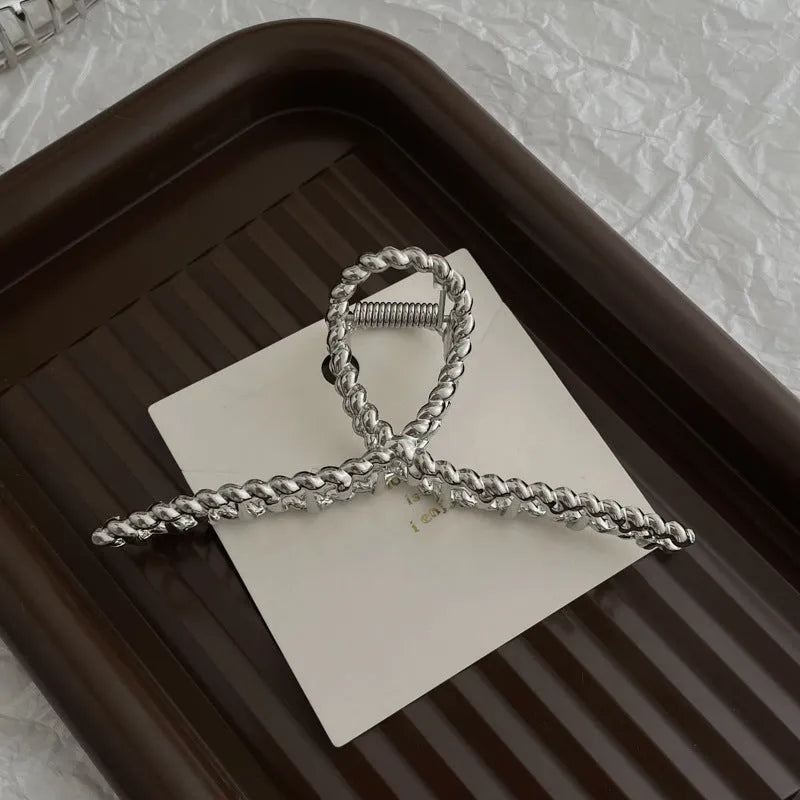 Assortment of silver metal hair barrettes and claw clips in various Korean-style designs on a white background.