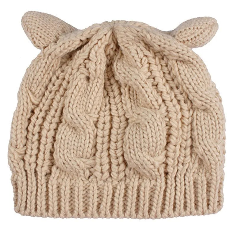 Hand-made red knitted beanie with 3D cat ears on a white background