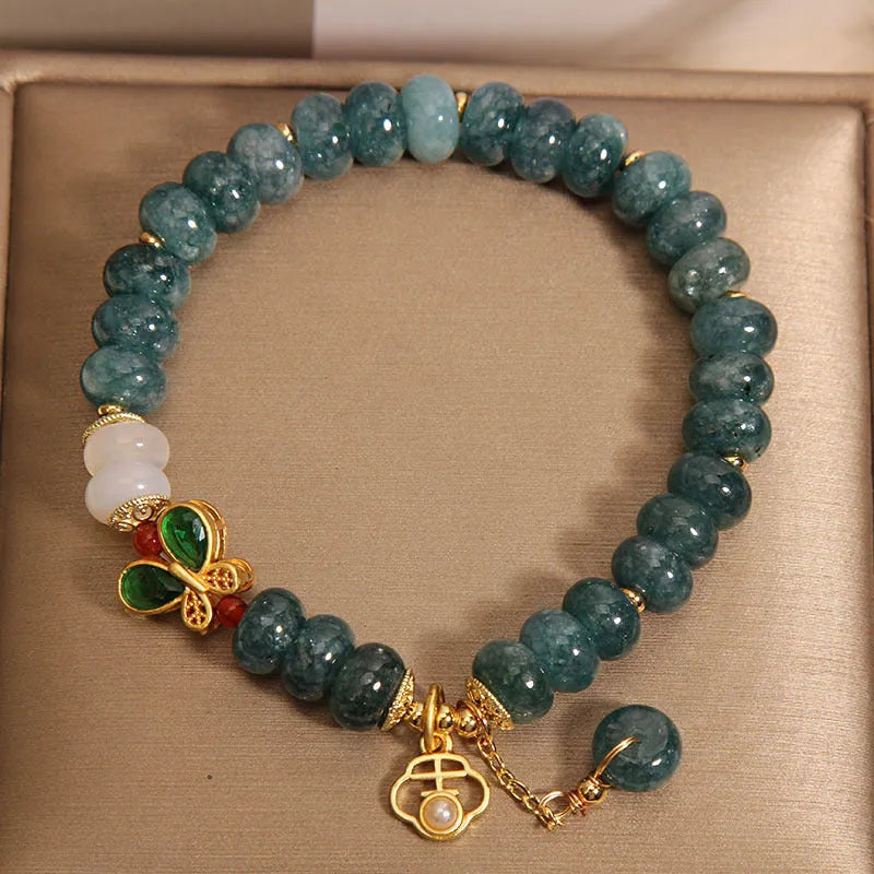 Women's blue water jade abacus bead bracelet with alloy charms, white agate, and rhinestone details