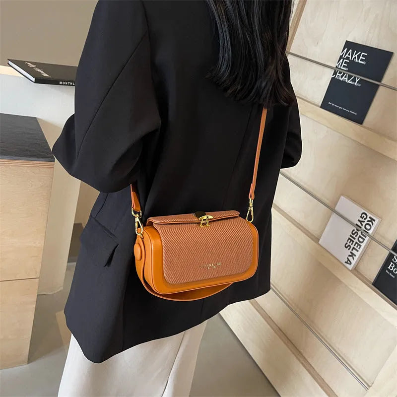 Women's black PU leather messenger bag with contrast stitching and a lock detail.