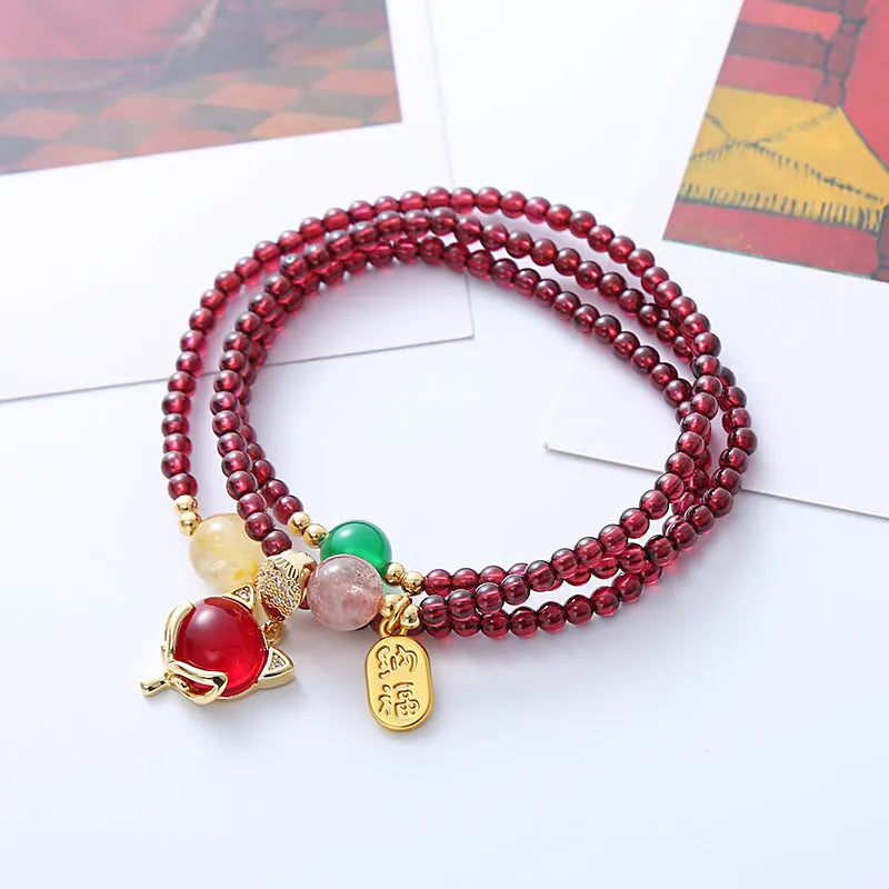 Purplish red garnet fox bracelet on an adjustable rope for women.