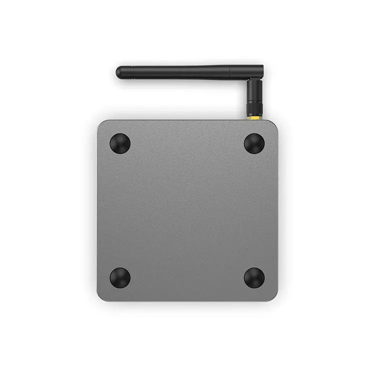 Android smart TV set-top box with voice remote control on a wooden table.