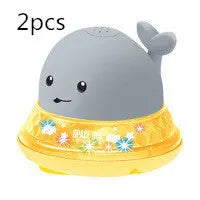 White and blue whale bath toy spraying water with LED lights illuminated