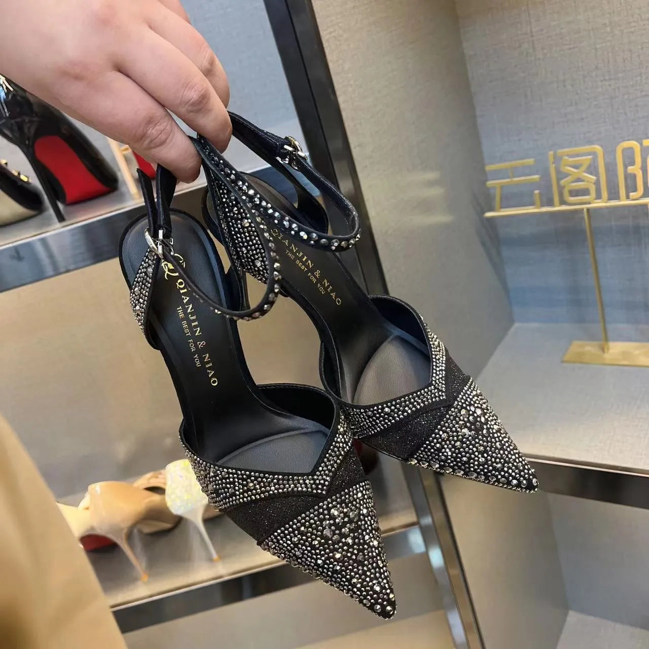 Women's black hollow stiletto heel pumps with a red sole and pointed toe.