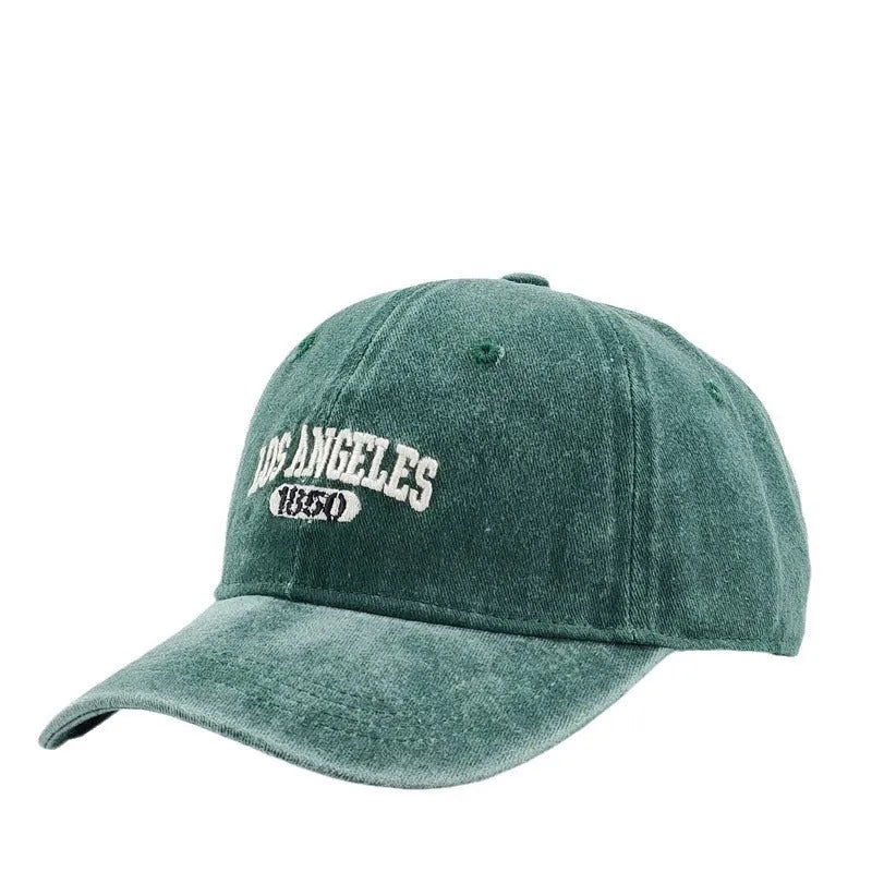 Retro-style adjustable acrylic peaked cap with embroidered letters, shown in a distressed beige colour.