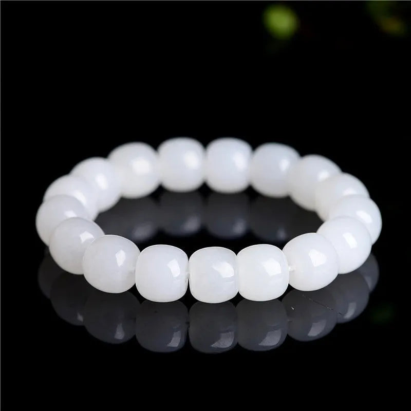 White Hetian jade barrel bead bracelet on a wrist, showing the smooth stone beads and unisex casual design.