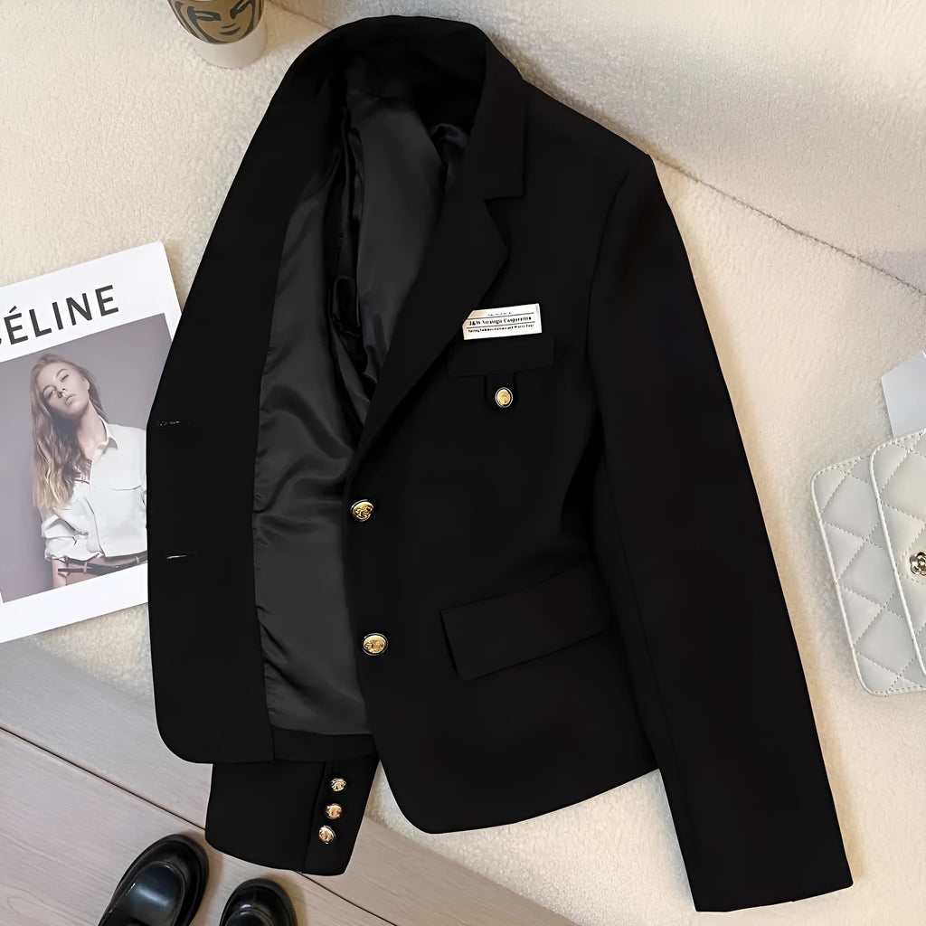 A women's black loose-fitting short suit coat with long sleeves and pockets.