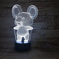 Black koala night light with colourful LED glow on a small table, showing remote control.