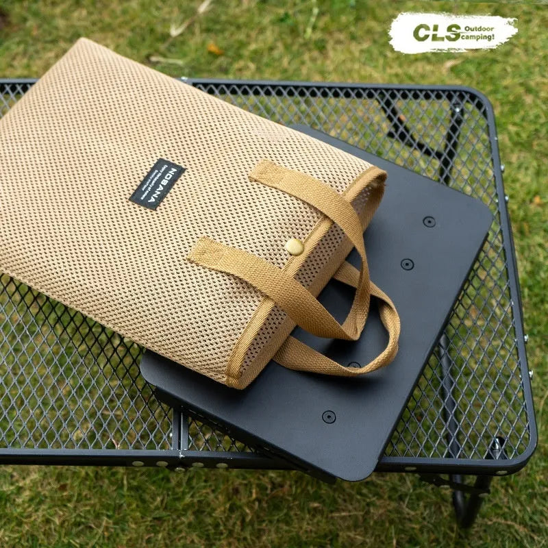 CLS aluminium folding camping stool shown in army green, converted into a small raised table next to a storage bag.