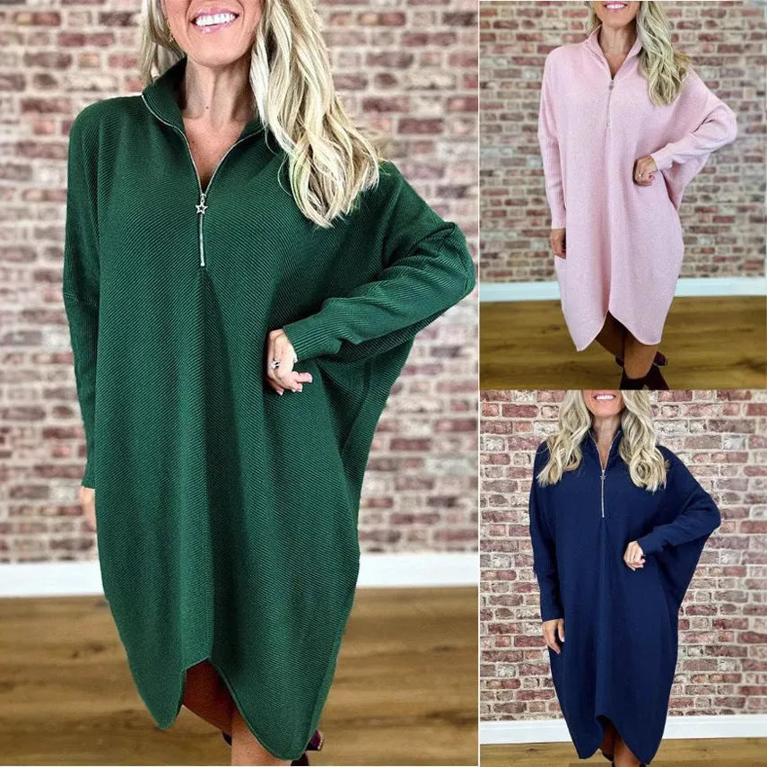 A woman wearing a loose-fitting solid colour knitted dress with raglan sleeves and a front zipper.