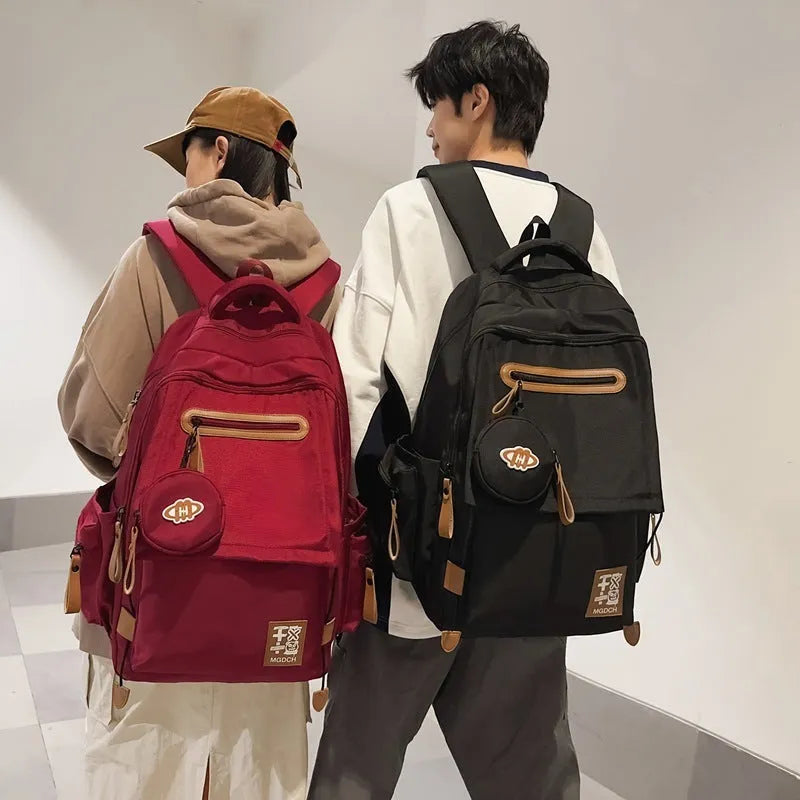Street style large capacity nylon backpack for middle school students in solid colour with curved shoulder straps.