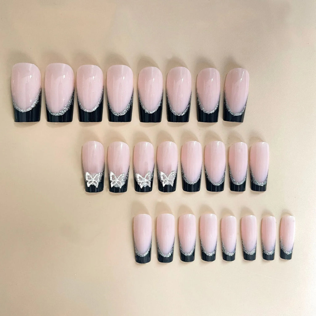 French-style false nails with glittering butterfly design in medium length with jelly glue adhesive