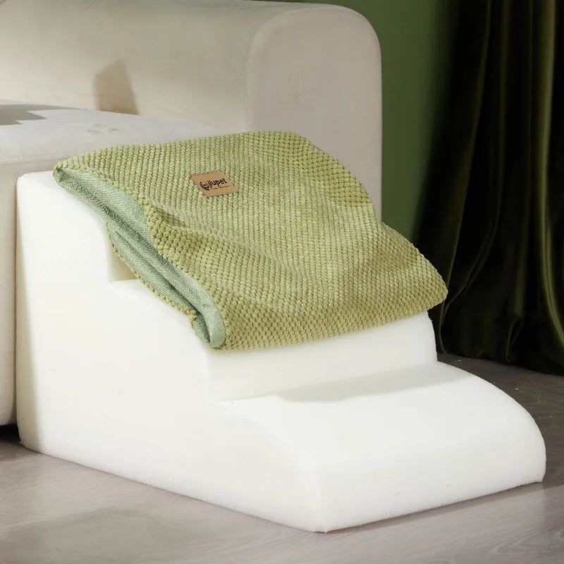 Brown foam pet ramp stairs with non-slip surface on a carpeted floor