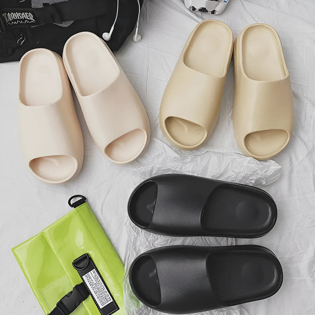 A pair of women's thick-sole beach slippers in a choice of colours, shown on a sandy background.