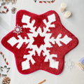 Round red and green Christmas pattern carpet on a wooden floor.