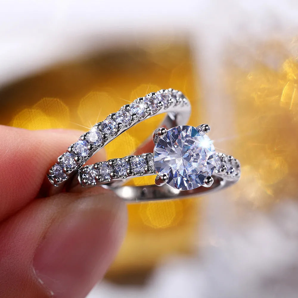 Two matching copper couple rings with a white gold finish and a small zircon stone inlay on a white background
