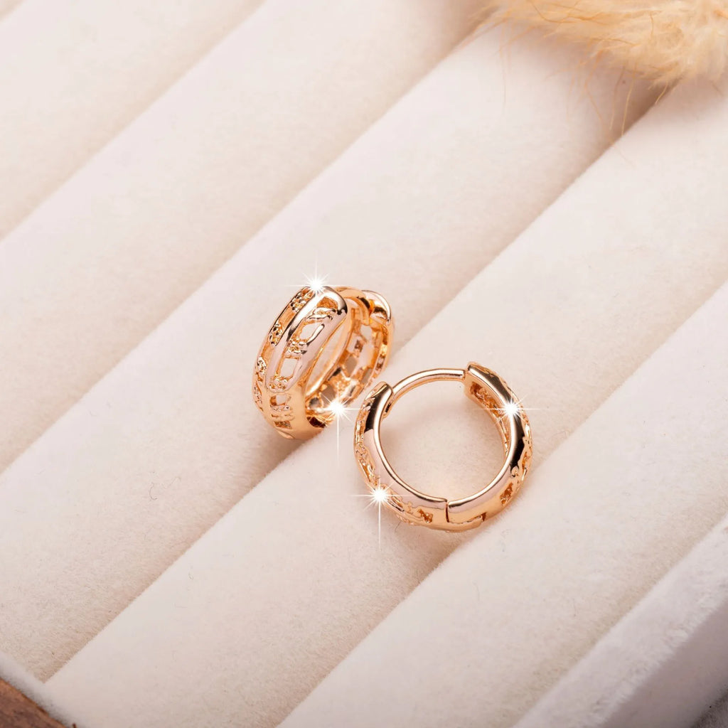 Small copper earrings with hollowed-out leaf and heart shapes in rose gold colour.