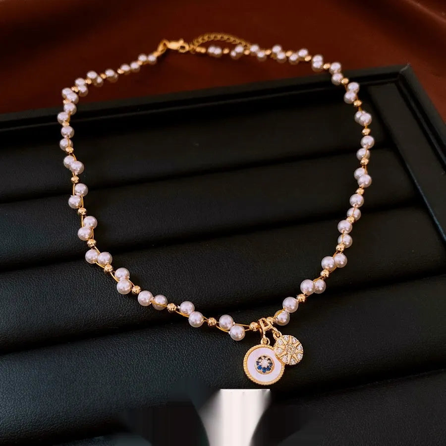 Golden-white electroplated necklace with round pearl pendant on adjustable clavicle chain