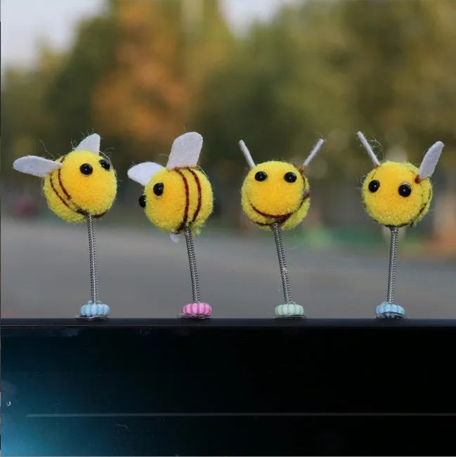 Small, soft, cartoon bee car decoration made from yellow and black fur ball material.