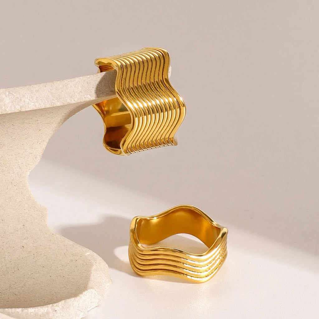 Stainless steel wide wave ring with geometric design and electroplated finish.