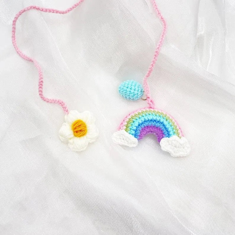 Handmade crocheted avocado-shaped car pendant in wool, shown in three colour variations.