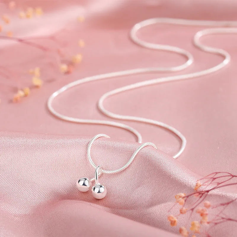 Silver cherry necklace for women with adjustable snake bone chain and fruit-shaped pendant.