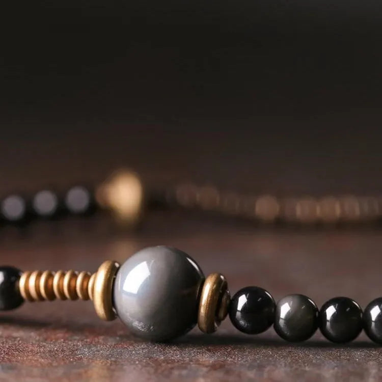 Black multi-layered beaded bracelet with geometric styling on wrist