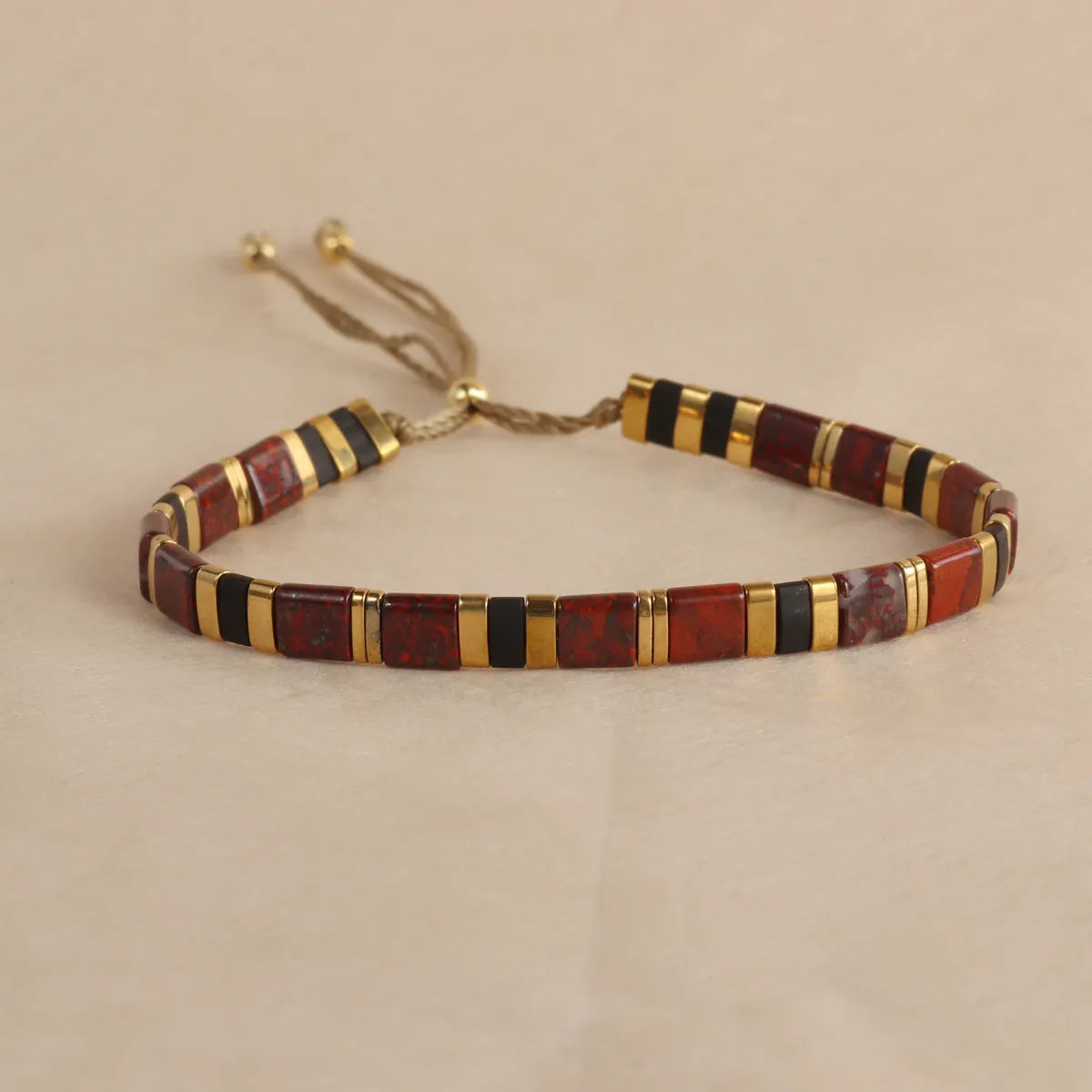 Geometric glass and coloured glaze beaded bracelet with a pull clasp in milky white colour.