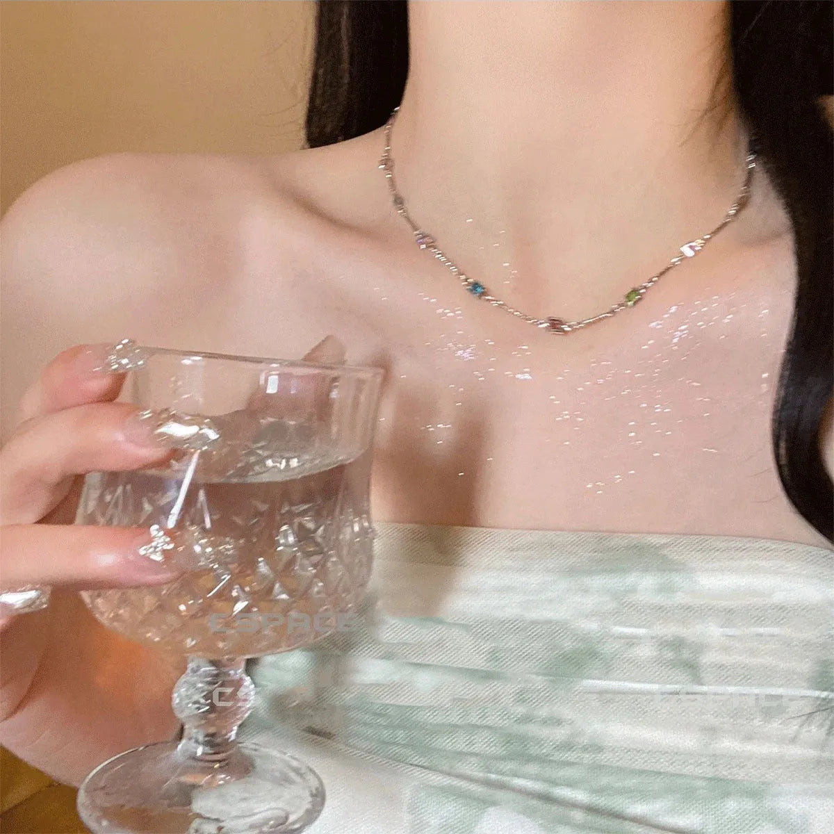 Square geometric clavicle chain necklace in gold tone with artificial crystal details on a white background.