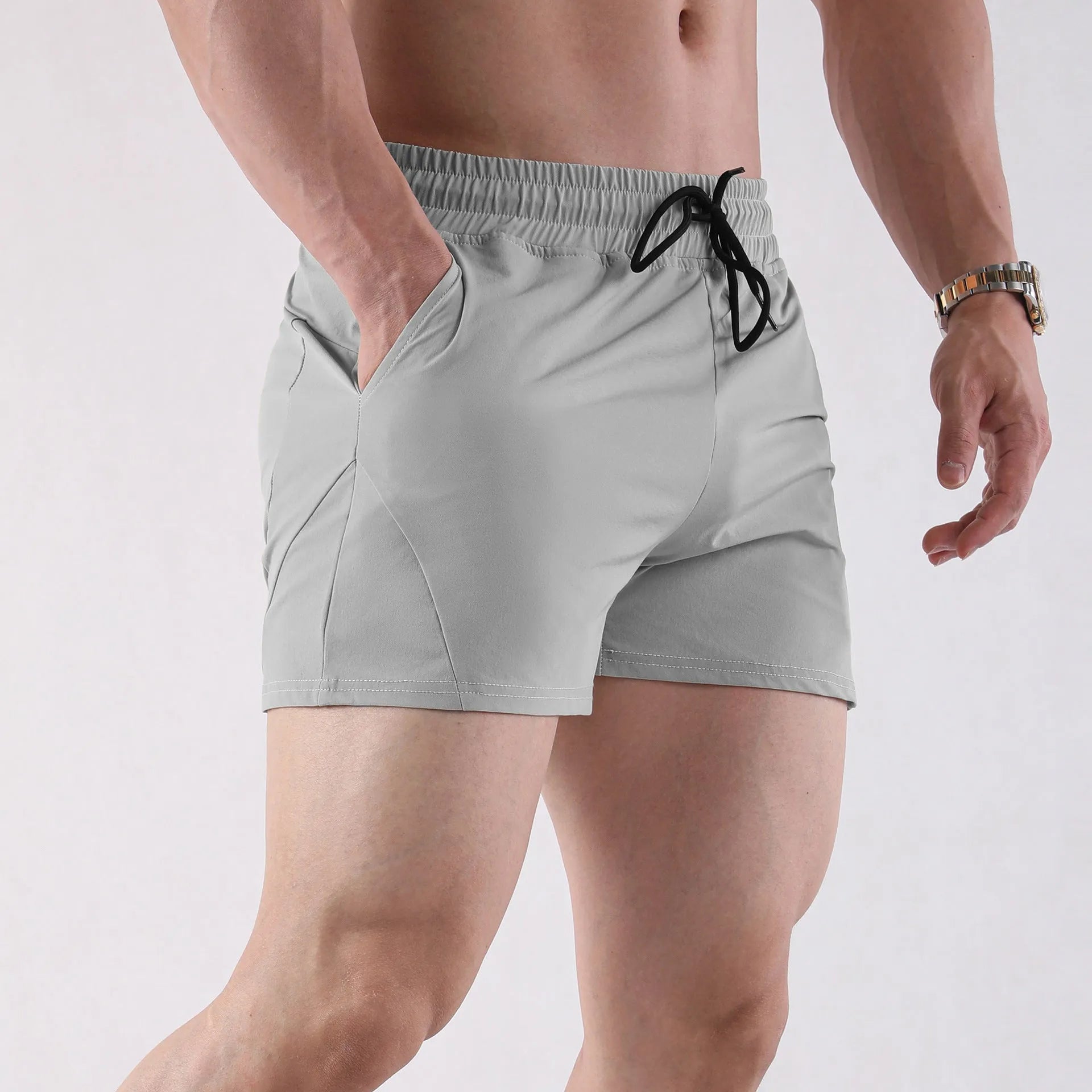Men's thin polyester basketball shorts in grey, shown in a sports setting.