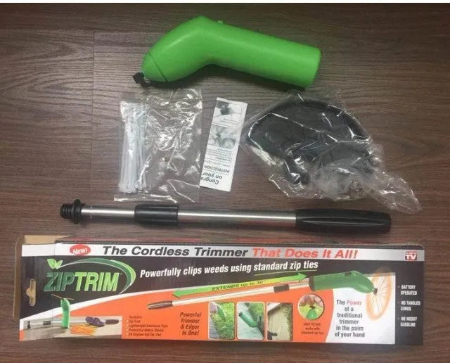 Cordless zip tie lawn trimmer with extension pole and protective debris shield on grass.