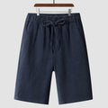 Man wearing beige linen cropped shorts with a loose fit and elasticated waistband.