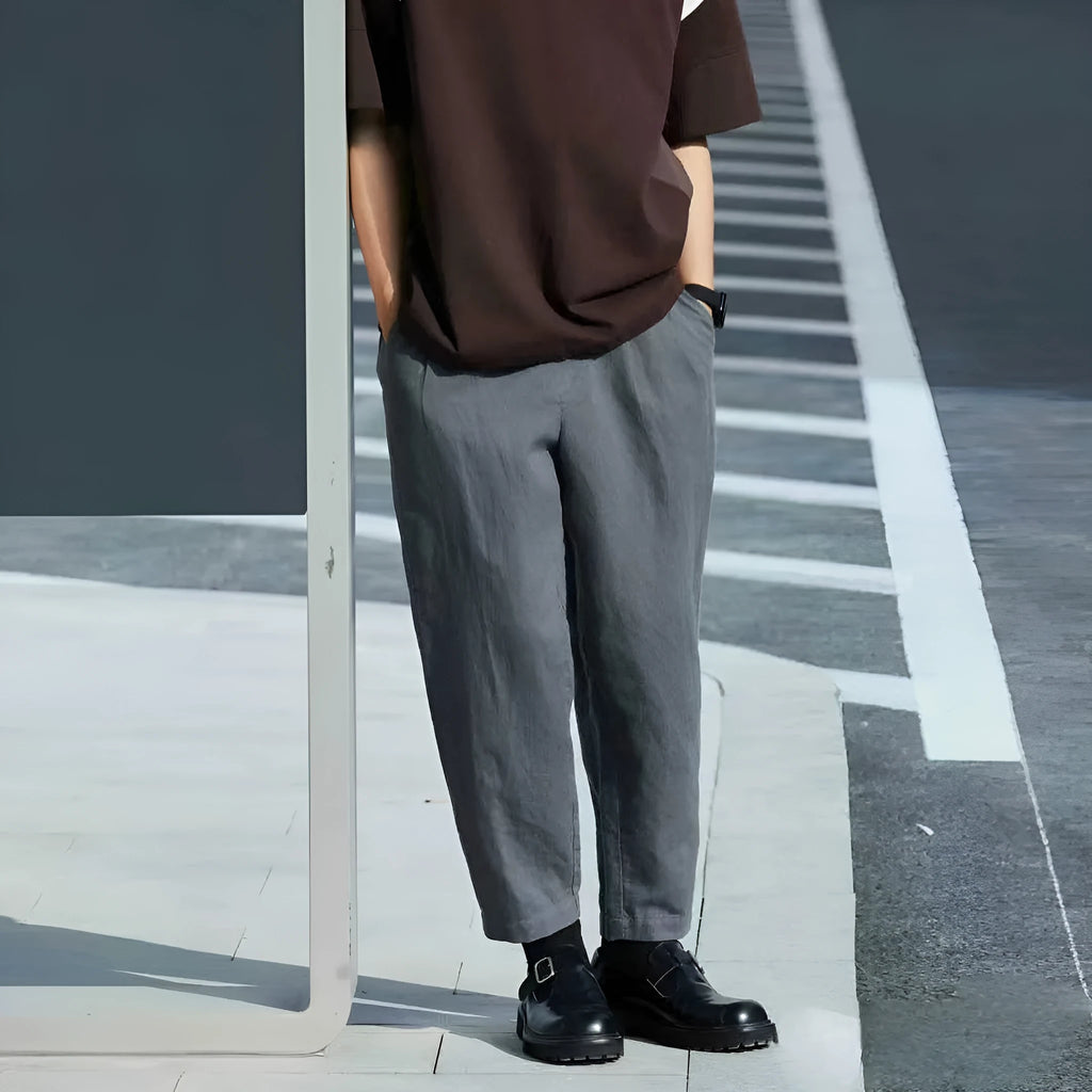 Man wearing beige loose straight-leg casual trousers with a drawstring waistband.