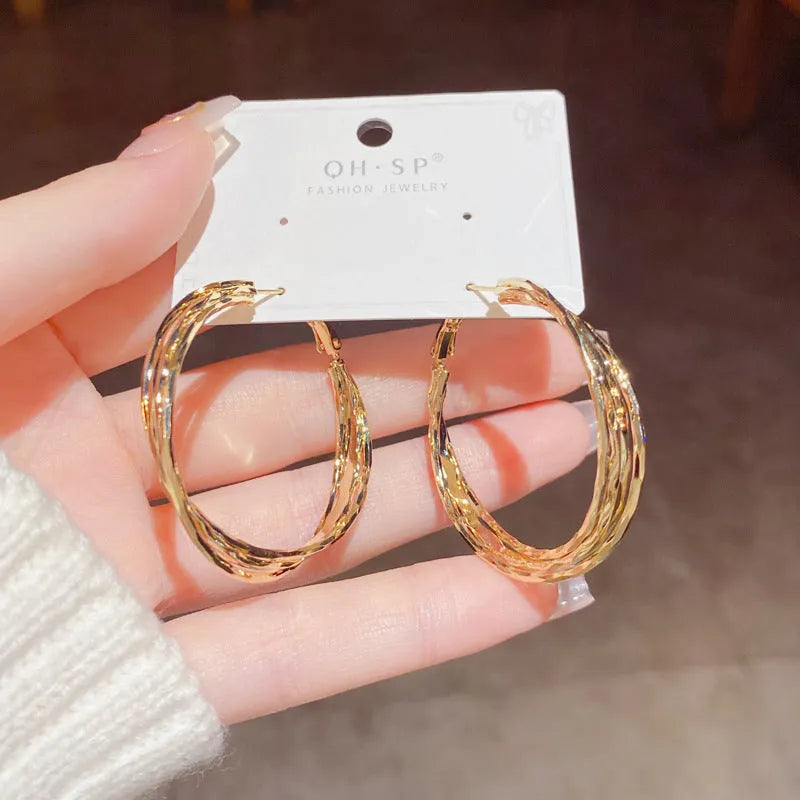 Gold metal twisted earrings with round geometric shape on copper base